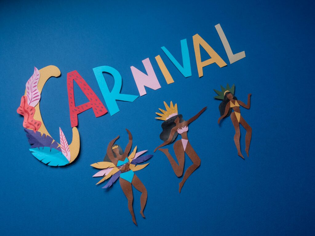 Vibrant paper cutouts depict Carnaval dancers against a striking blue backdrop.